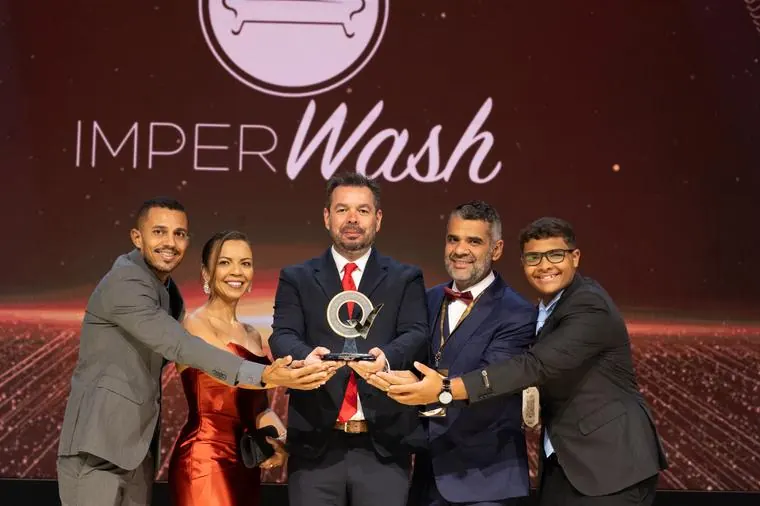 Entrega de troféu no palco da cerimônia de premiação 2026