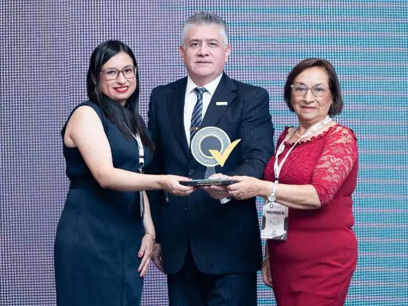 Empresa reconocida recibe el trofeo en el escenario