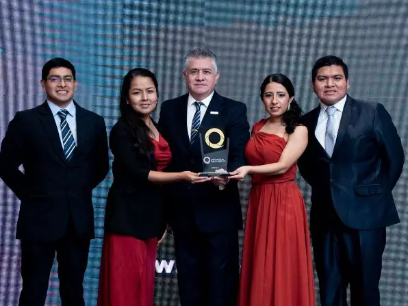 Equipo reconocido con el trofeo en el escenario