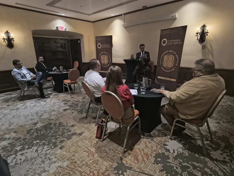Conversación con invitados en un salón con los banners de la certificación Q-ESG