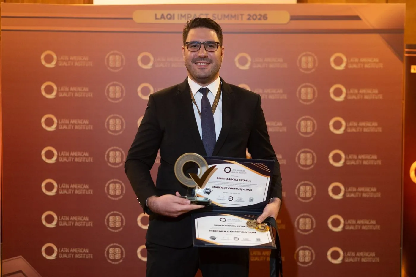 Empresario recibe trofeo y certificado LAQI en el photocall del Summit
